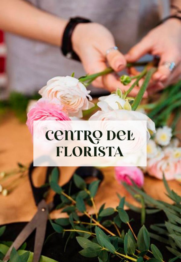 Muestra las manos de un florista creando un centro de flroes